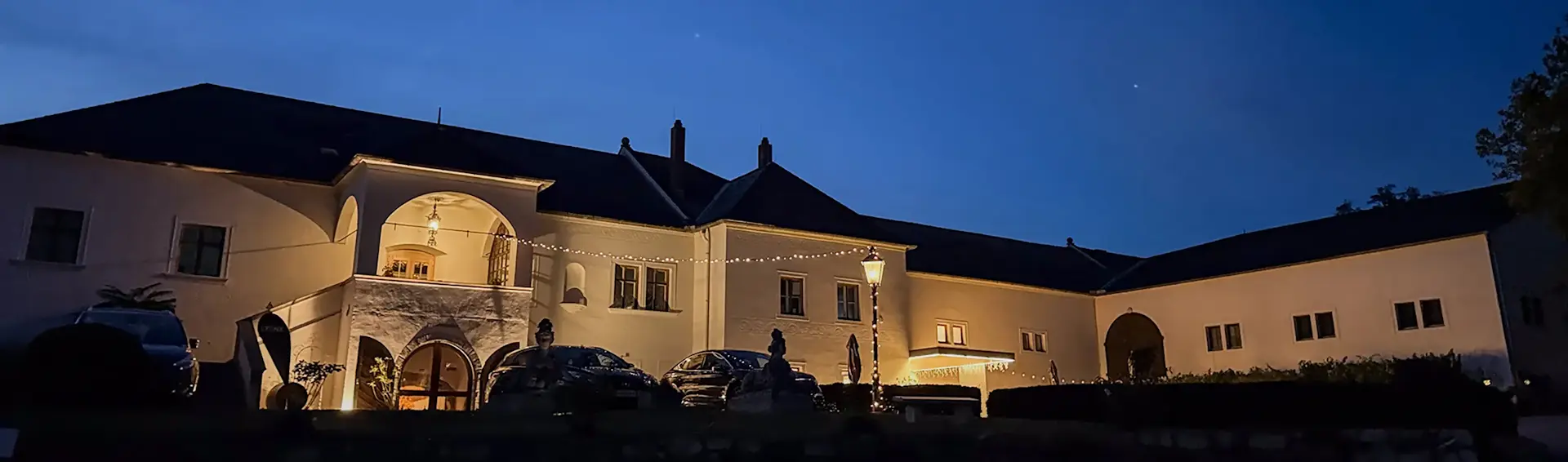 Das historische Gebäude des Freigut Thallern in stimmungsvoller Abendbeleuchtung – die exklusive Location für das LYYNX MLP-Training.